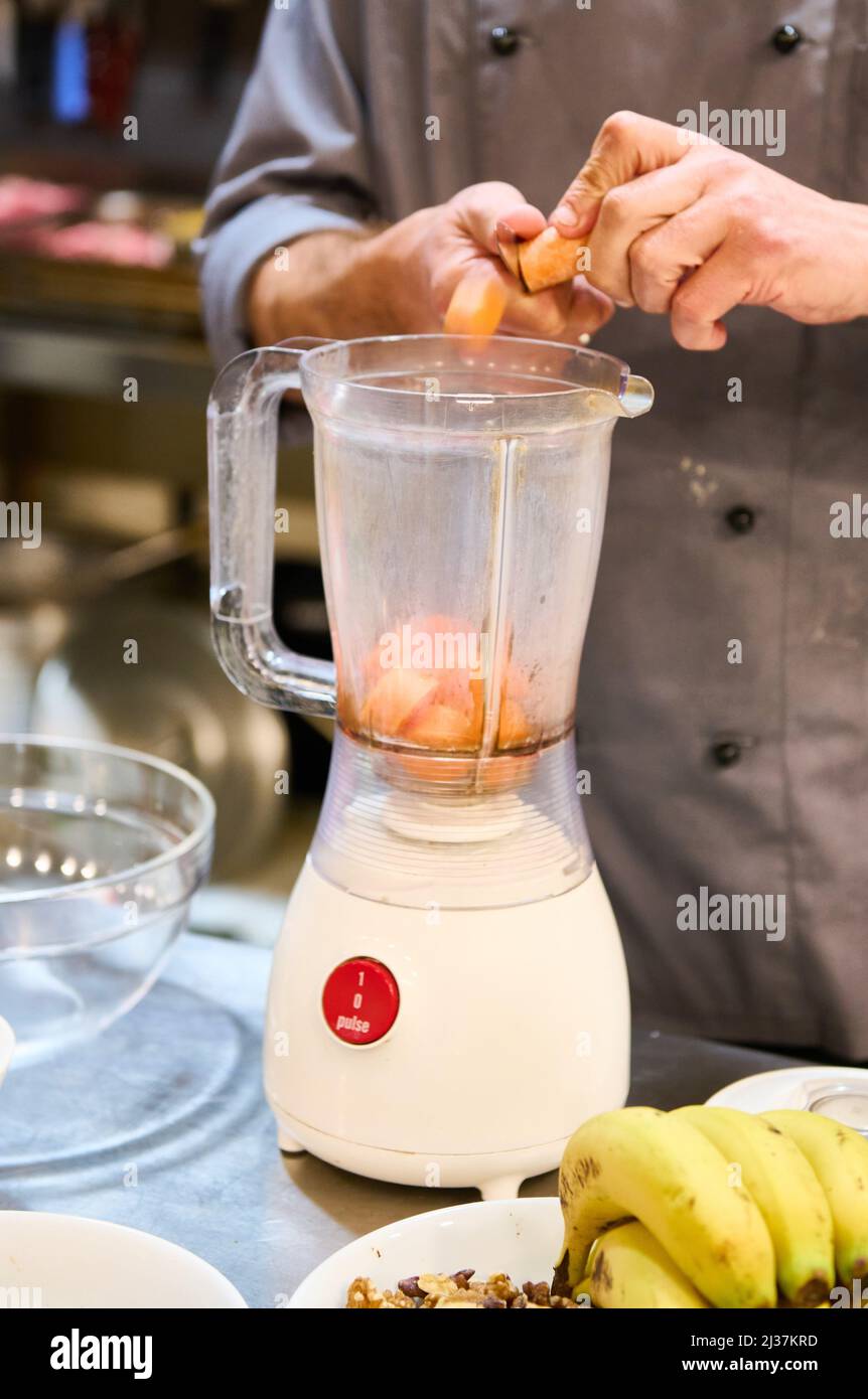 Chef picando zanahorias dentro de una batidora para hacer zumo de fruta  Fotografía de stock - Alamy