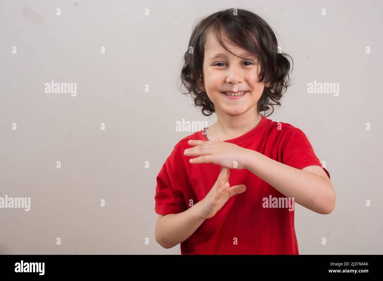 Niño sonriente haciendo una pausa o un gesto de la mano del tiempo del descanso. Foto de stock