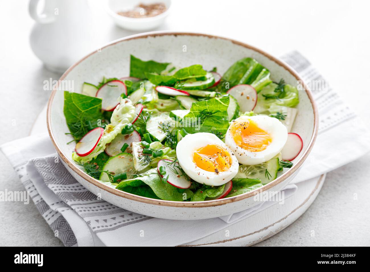 Ensalada con rábano, pepino, lechuga romana y huevo cocido suave Foto de stock
