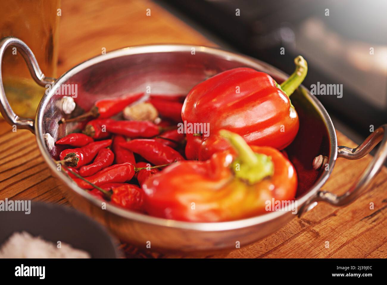 A algunos les gusta el calor. Tiro de una sartén llena de pimientos rojos y chiles sobre una mesa. Foto de stock