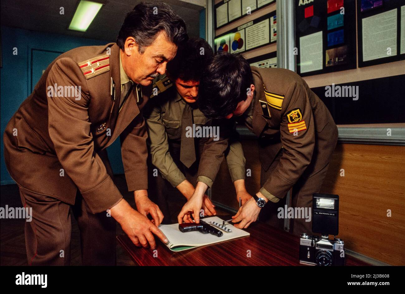 Escuela de formación de la KGB, Moscú, Rusia, URSS 1990. Profesor y estudiantes en la sección de fotografía forense mirando una bala para una escena del crimen. Foto de stock