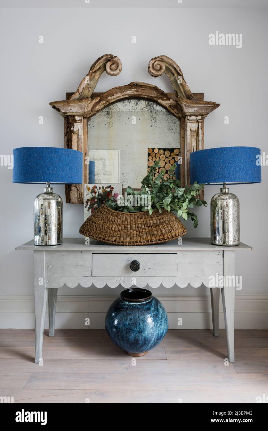 Un par de lámparas azules con un gran espejo antiguo y una cesta en la casa renovada de St Ives, Cornwall, Reino Unido Foto de stock