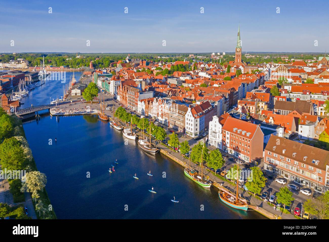Vista aérea sobre el río Trave y antiguos barcos de vela y barcos en el casco antiguo de la ciudad hanseática de Lübeck, Schleswig-Holstein, Alemania Foto de stock