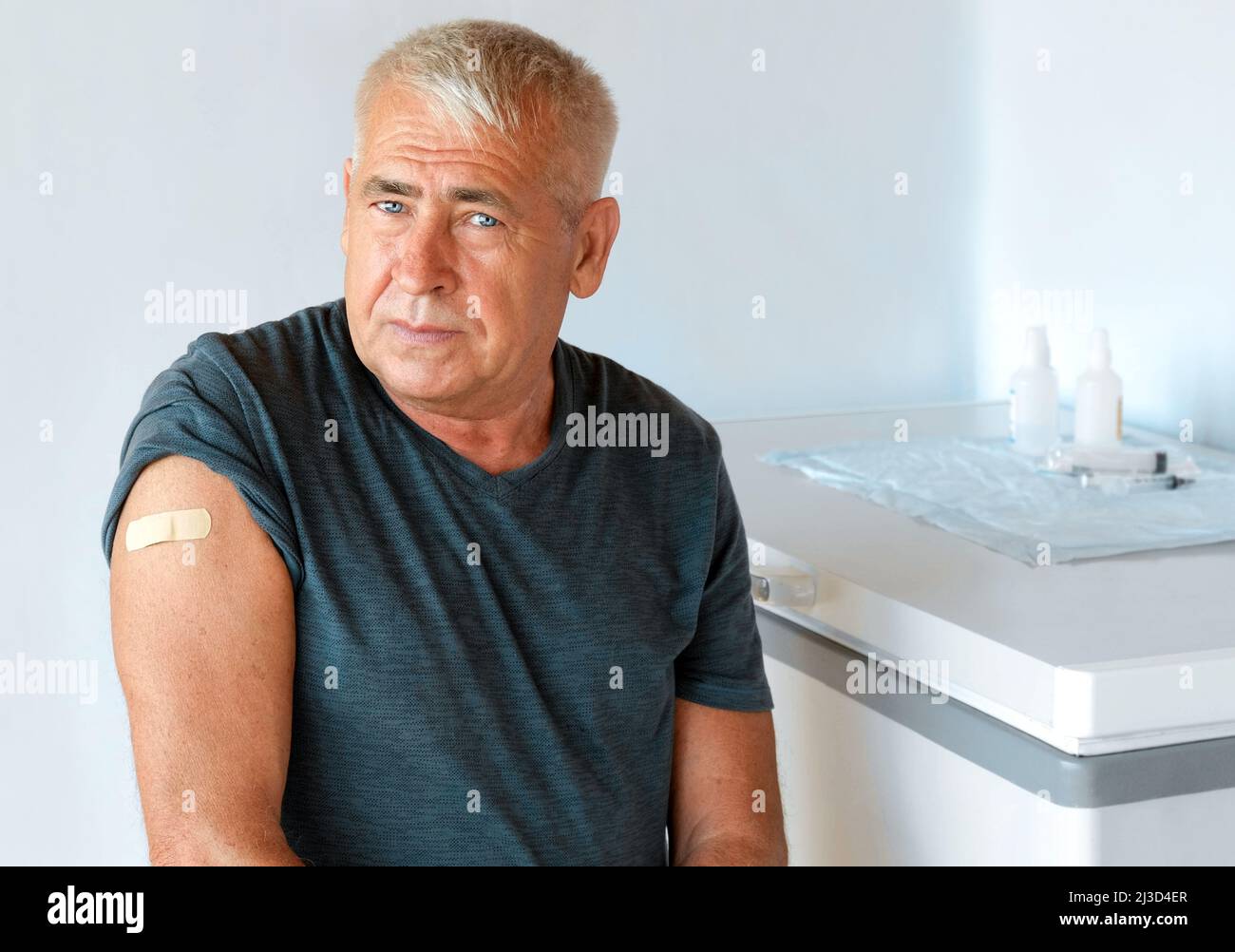 Ancianos después de la vacuna COVID-19. Hombre de edad avanzada. Vacuna contra el Coronavirus. Vacunación para personas mayores. Hombre mayor mostrando su brazo con vendaje, parche Foto de stock