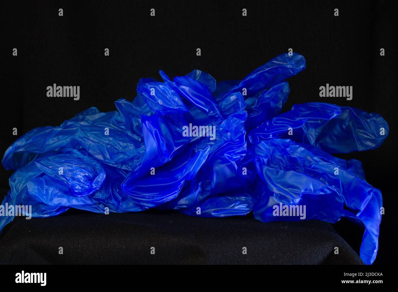 guantes de plástico de inspección de virus azul desechados y nuevos aislados un fondo negro Foto de stock