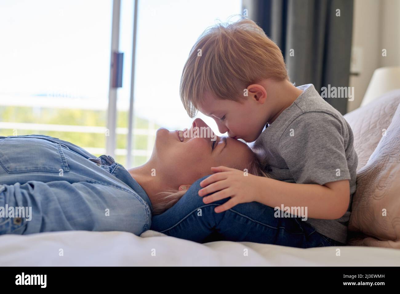 Expresiones de amor. Disparo recortado de un niño besando a su madre en casa. Foto de stock
