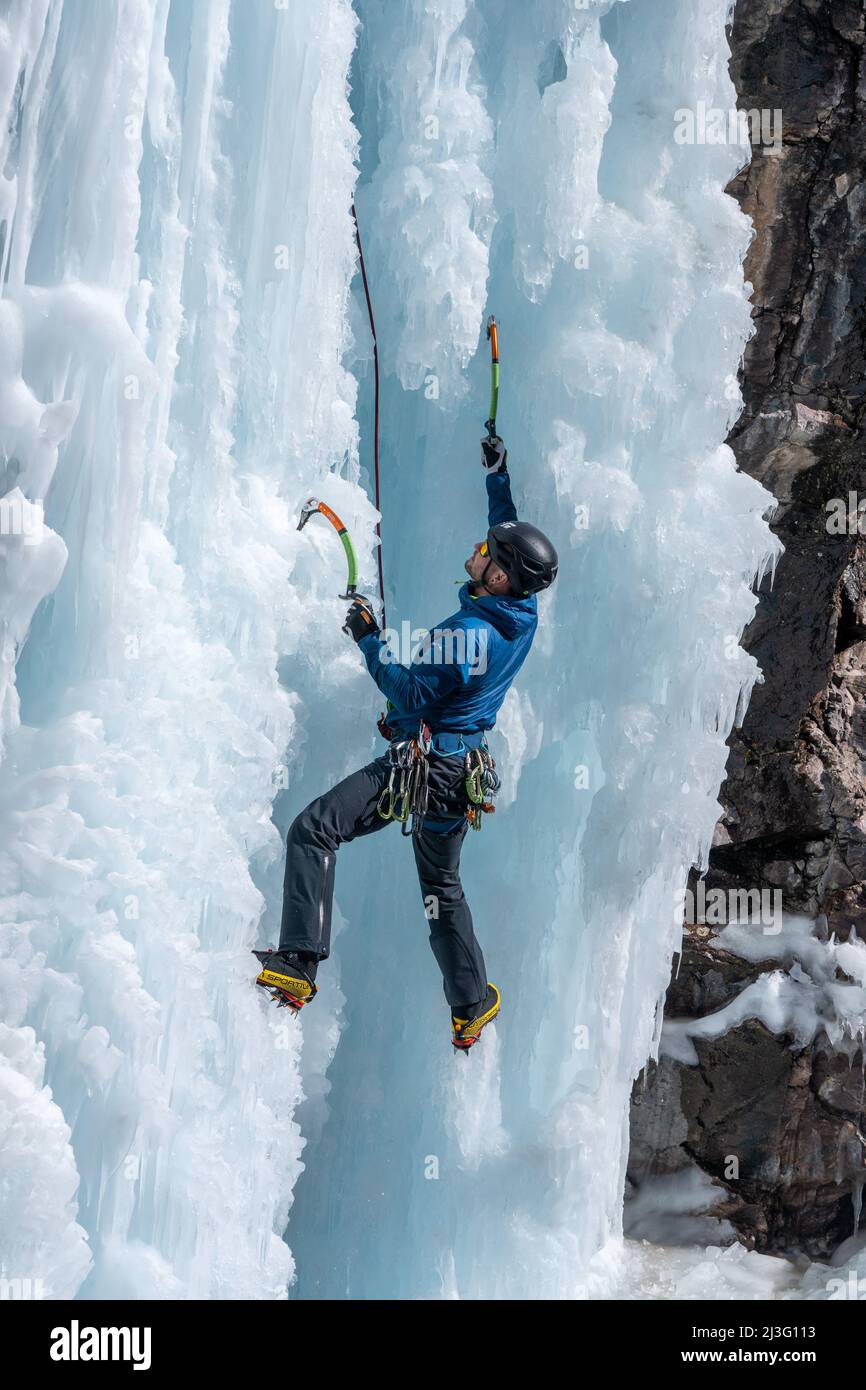 Escalador de hielo con crampones en botas de montaña - fotografía