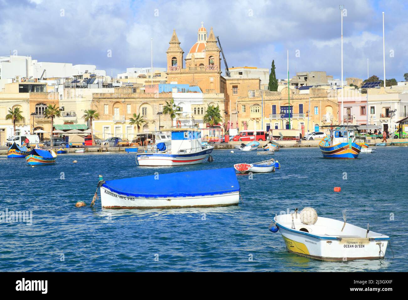 Malta, Marsaxlokk, puerto pesquero fundado por los fenicios en el siglo 9th a.C. JC con en el fondo la fachada de la iglesia parroquial de Nuestra Señora de Pompeya (1897) Foto de stock