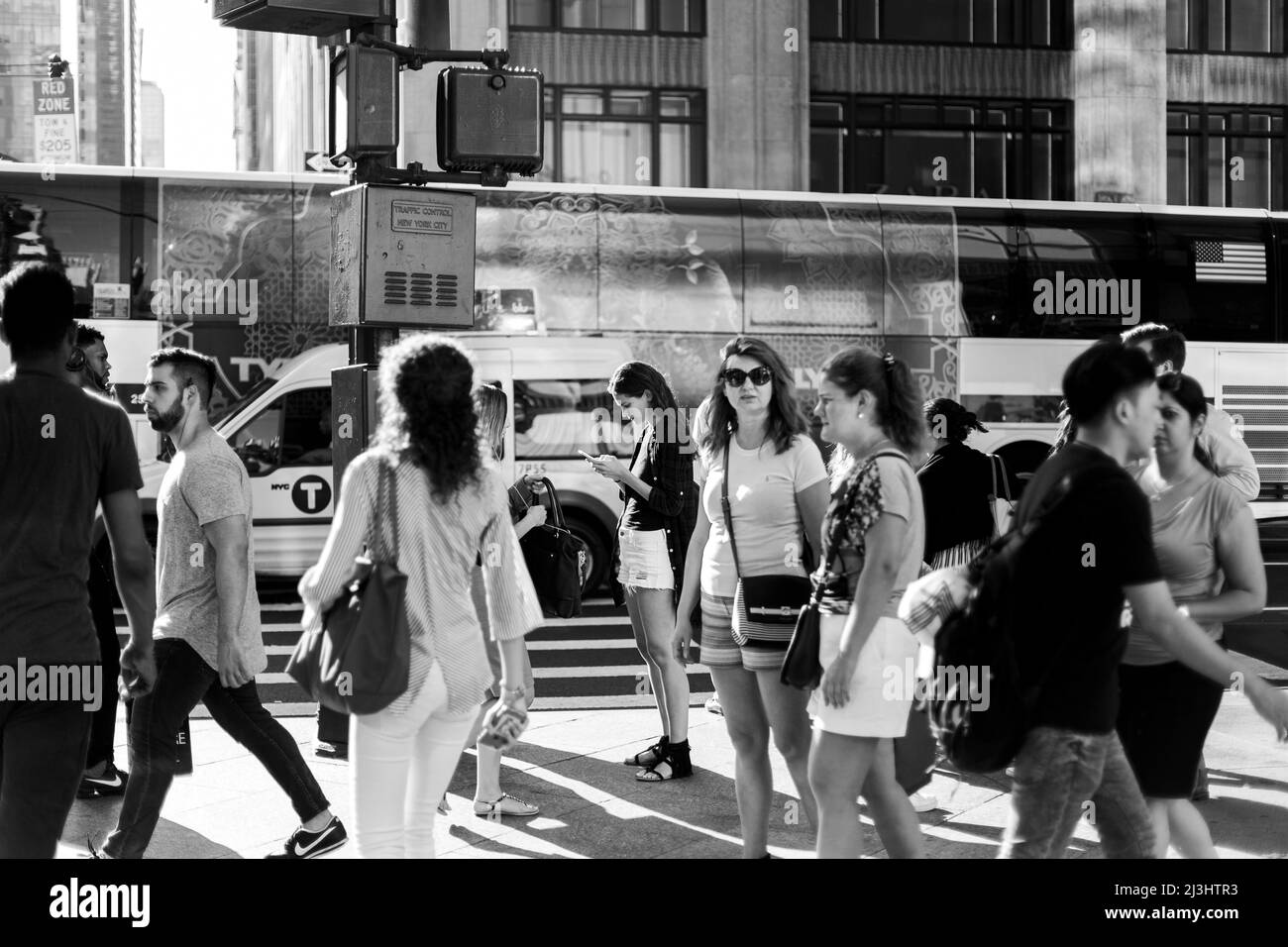 Midtown SOUTH, New York City, NY, Estados Unidos, una joven dama de pie en una multitud mirando su teléfono móvil Foto de stock