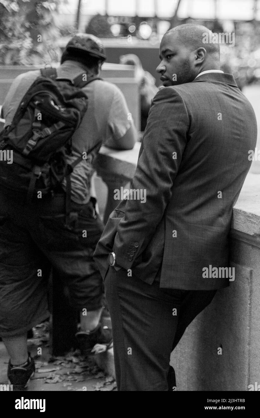 Midtown SOUTH, New York City, NY, Estados Unidos, hombre de negocios negro de buena apariencia apoyado en una pared Foto de stock