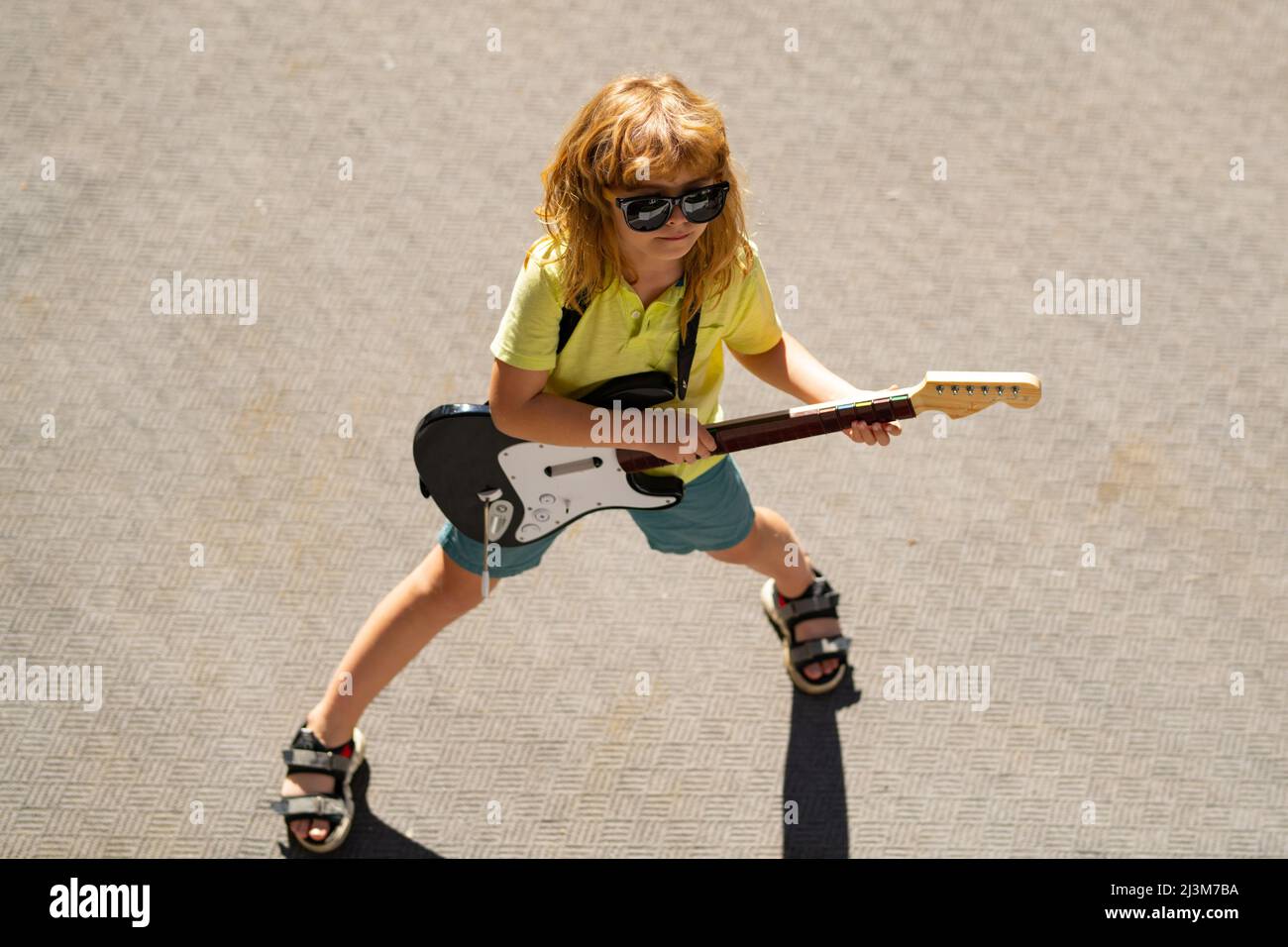 Niño tocando la guitarra al aire libre. Niño músico guitarrista tocando  guitarra eléctrica. Música para niños Fotografía de stock - Alamy