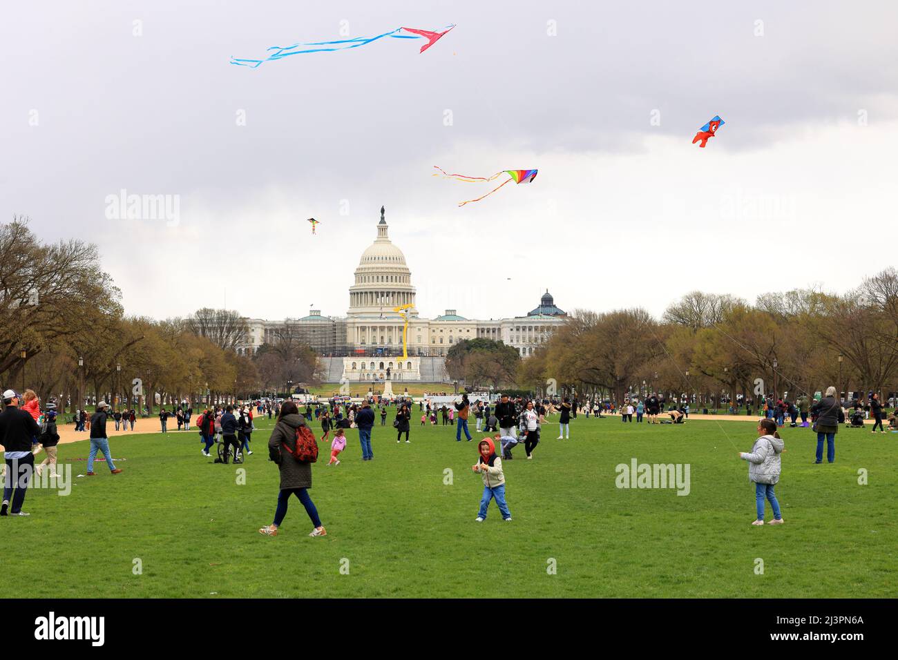 Niños, personas volando cometas en el National Mall con el Capitolio de los Estados Unidos al fondo durante el festival Cherry Blossom, Washington DC, 26 de marzo de 2022 Foto de stock