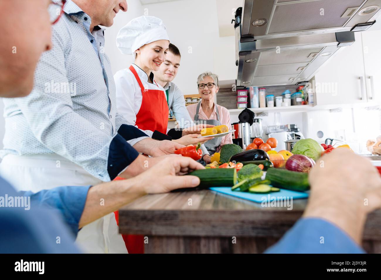 Personas que aprenden cocina saludable en una cocina de entrenamiento Foto de stock