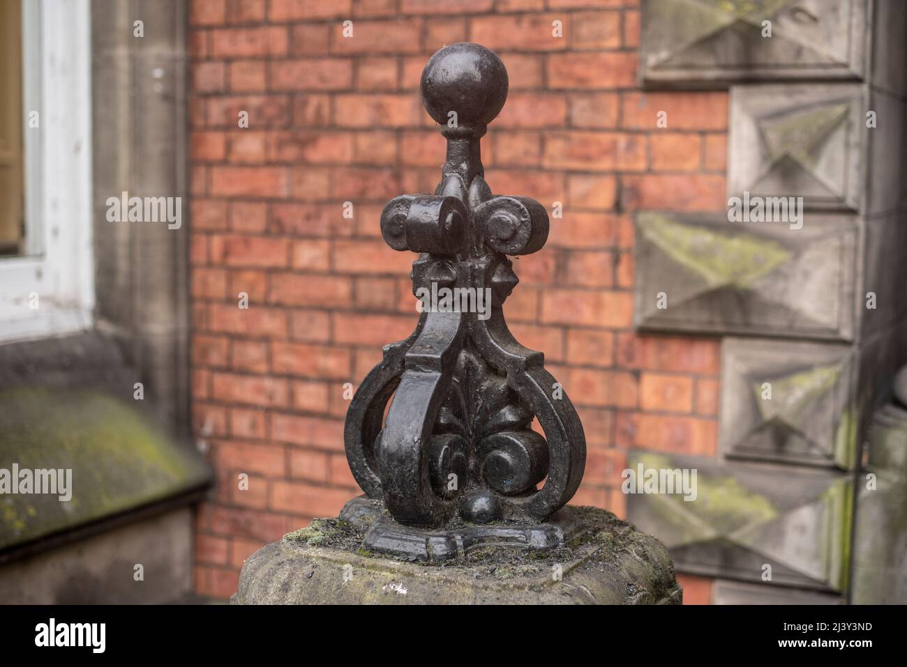 una gorra ornamental de hierro forjado en un poste de piedra en un edificio victoriano en inglaterra Foto de stock