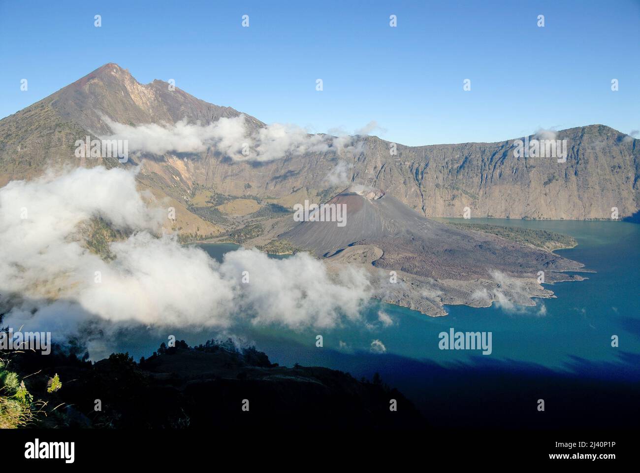 Vista de Gunung Rinjani y de Danau Segara Anak (Niño del Lago del Mar) dentro del cráter de Gunung Rinjani. También el cono de la escoria conocido como Gunung Baru. Foto de stock