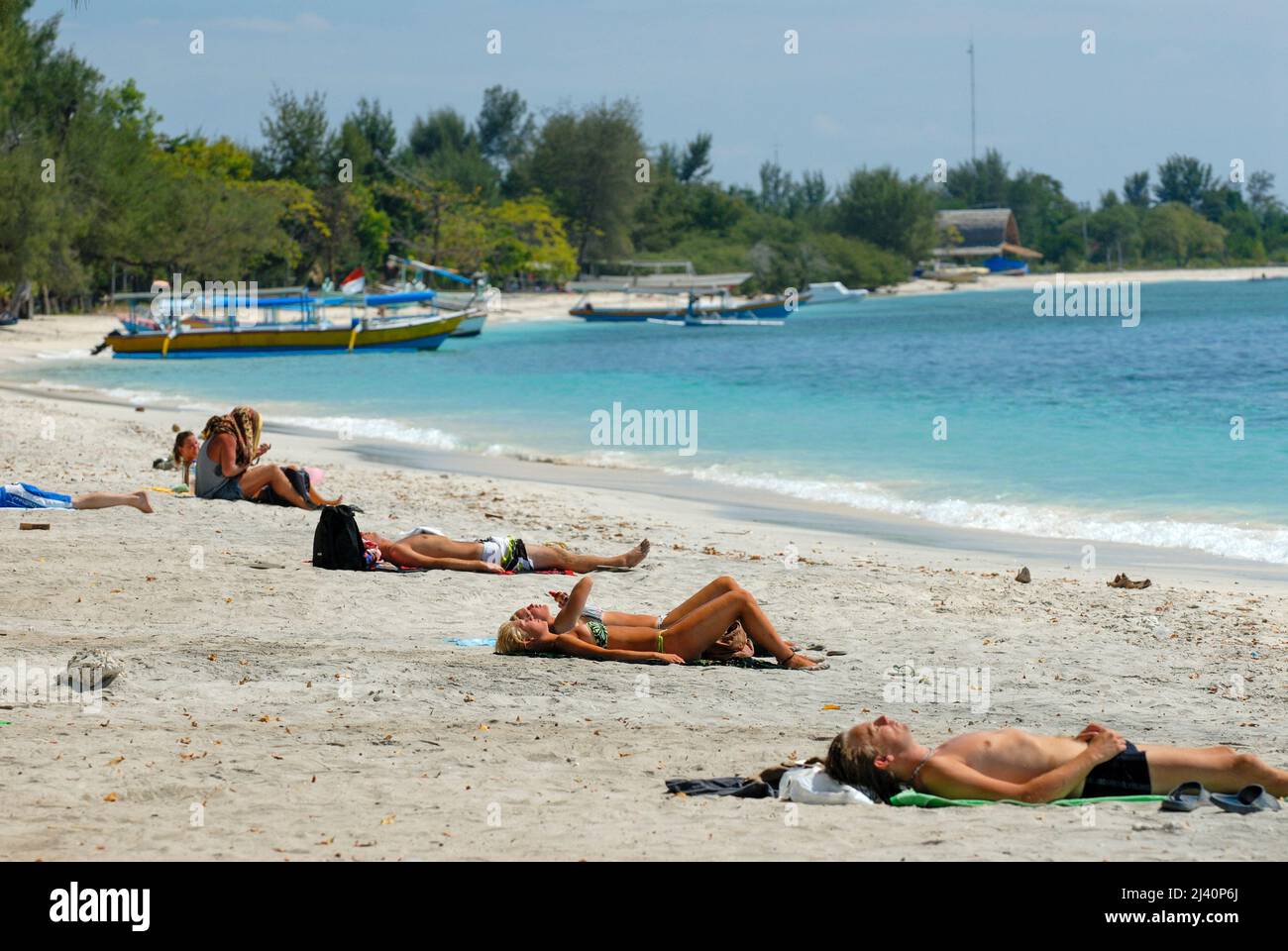 Los jóvenes turistas occidentales se relajan en una de las playas de Gili Trawangan. Foto de stock