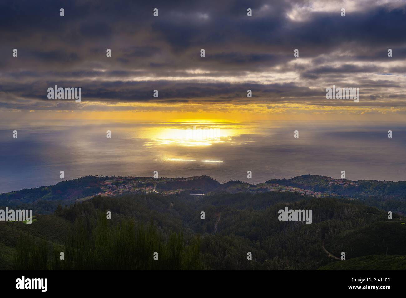 Puesta de sol sobre el Océano Atlántico con pueblos costeros en Madeira, Portugal Foto de stock