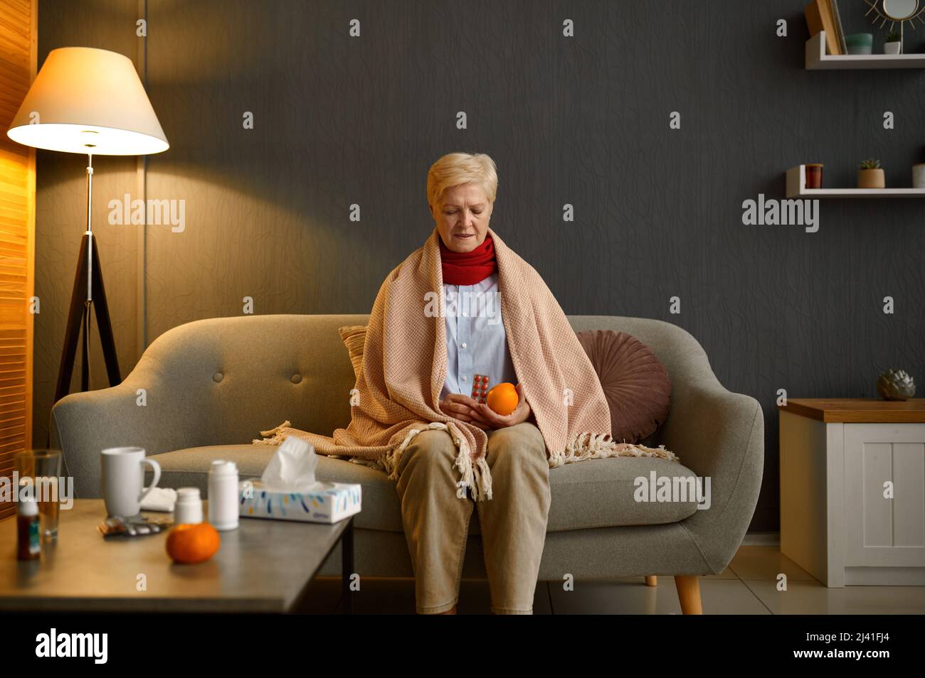 Una anciana enferma elige naranja o píldoras Foto de stock