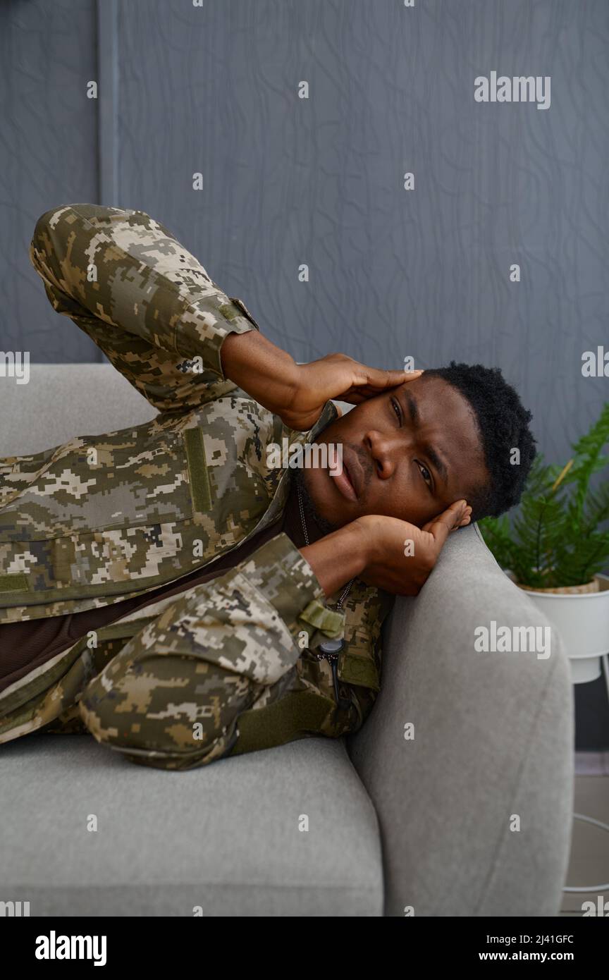 Hombre militar deprimido con dolor de cabeza frotando templos Foto de stock