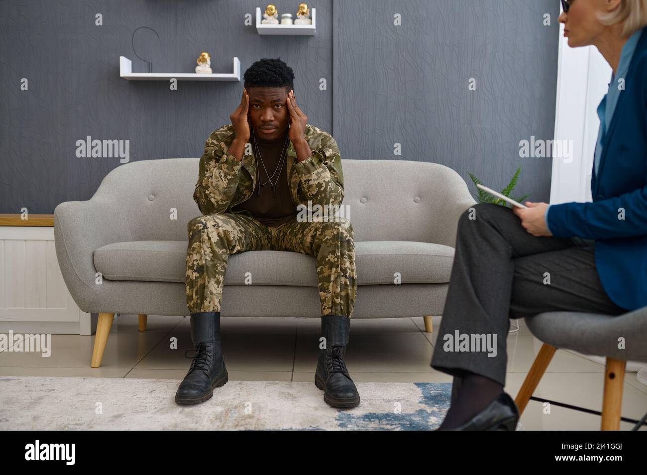 Paciente militar frustrado hablando con el psicólogo médico Foto de stock