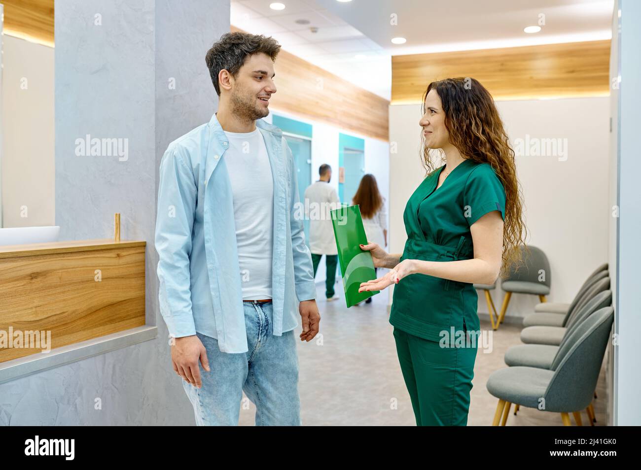 Hombre hablando con el médico en el salón de la clínica Foto de stock