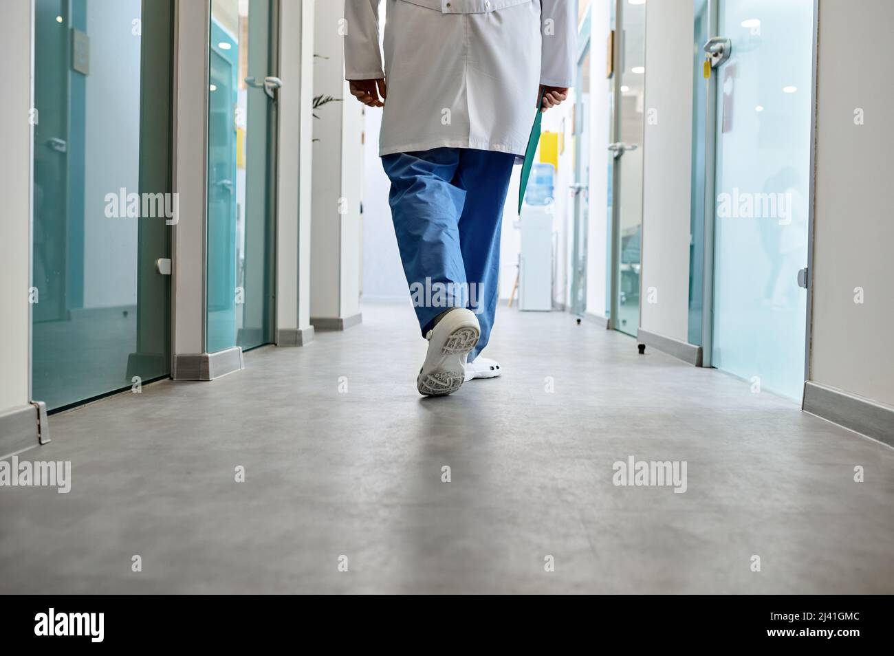 Médico caminando en el pasillo del hospital vista trasera Foto de stock