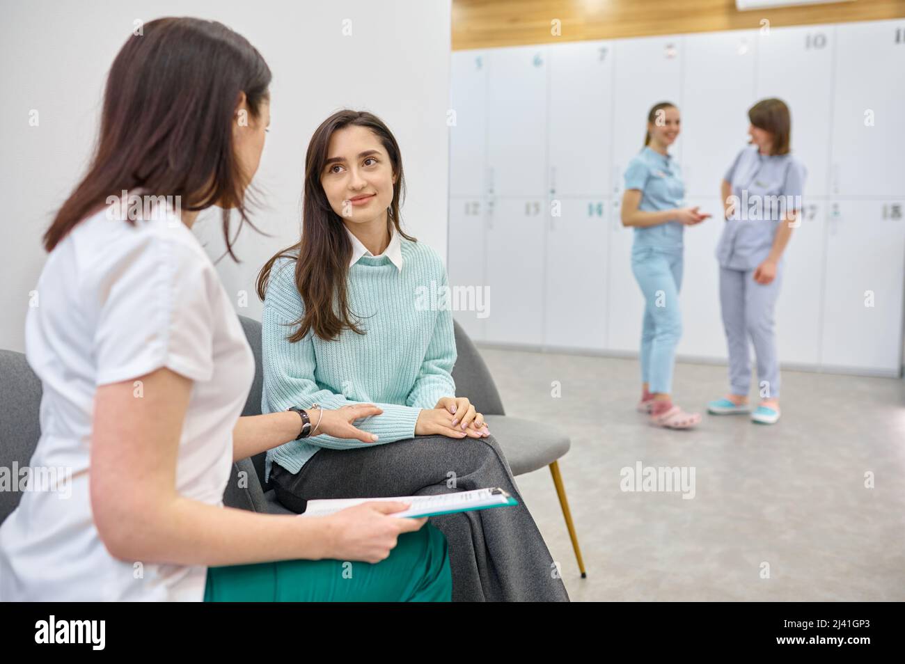 Médico hablando con un paciente adolescente en el pasillo Foto de stock