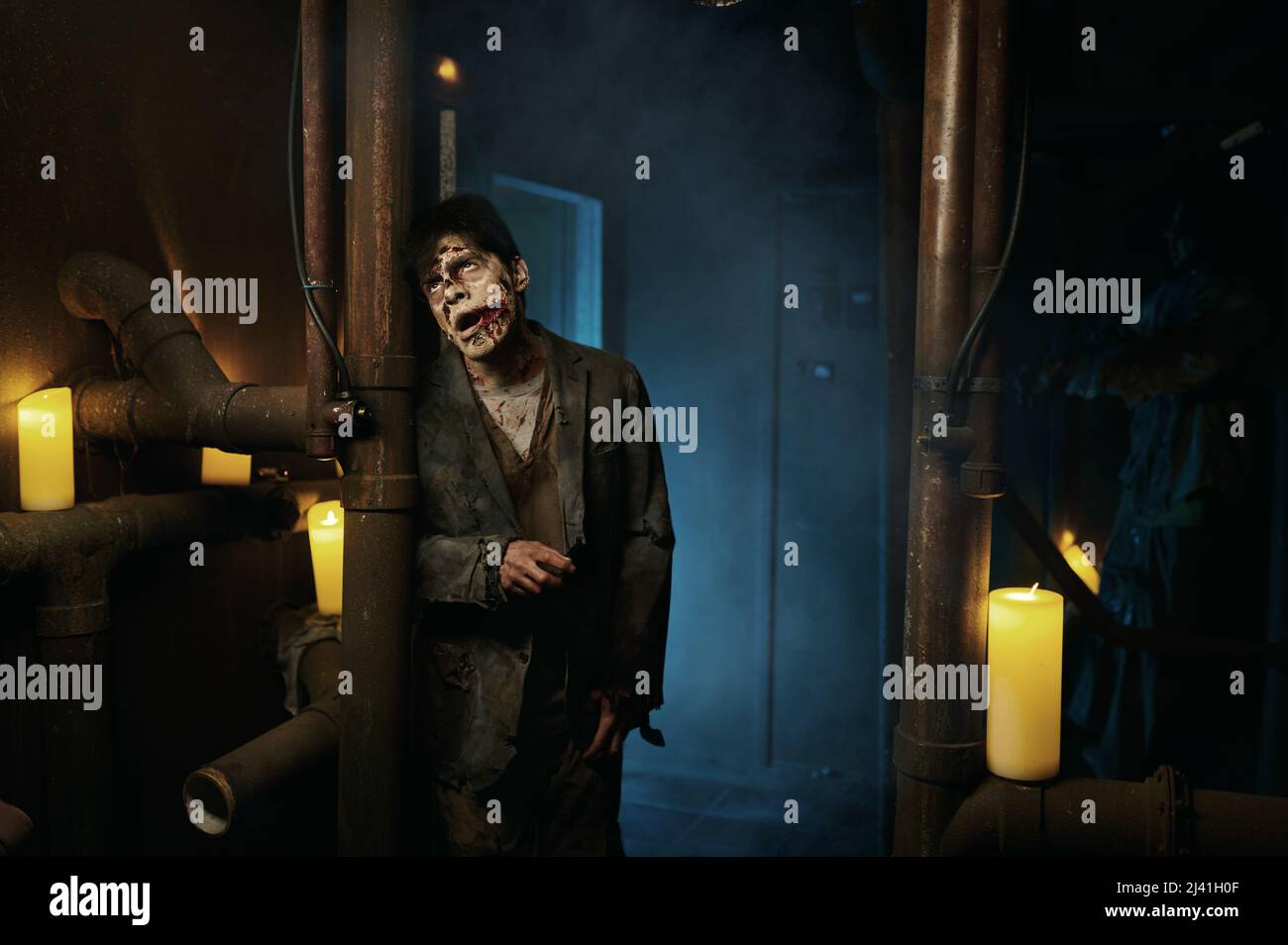 Hombre zombie en el sótano con pipas retrato Foto de stock