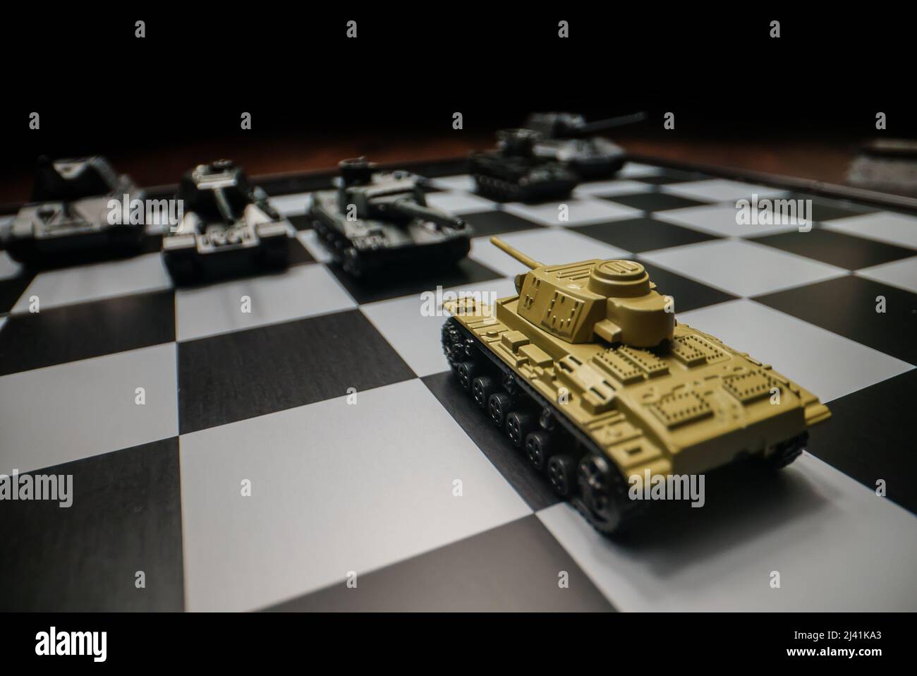 Tanques de juguete en un tablero de ajedrez. El concepto de estrategia militar. Foto de stock