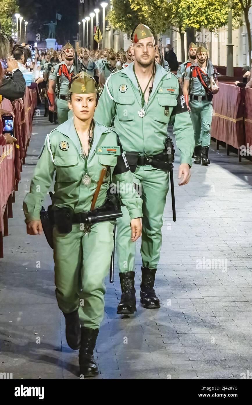 Huelva, España - 9 de abril de 2022: Mujer Soldier desfilar durante la Semana Santa de España por la noche. Legionarios de Legion Tercio durante el desfile Foto de stock