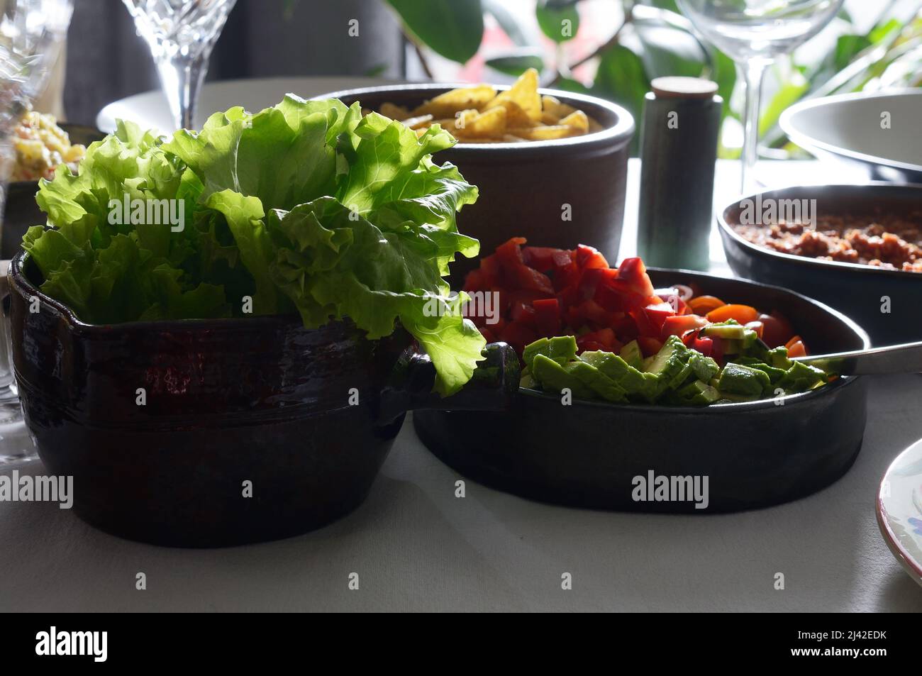 ensalada verde y plato de acompañamiento en la mesa Foto de stock