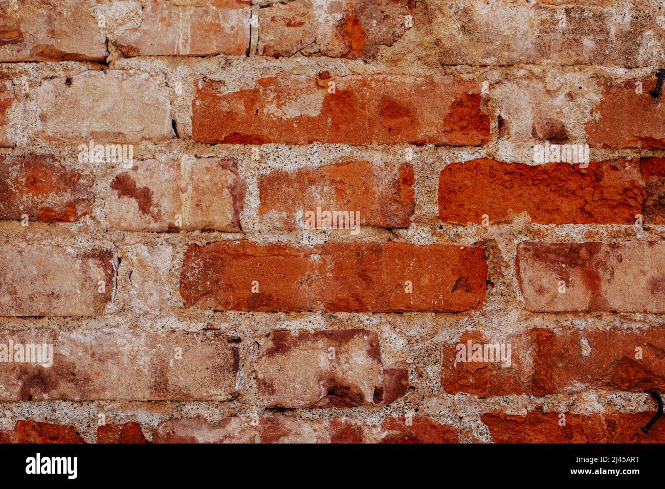Fondo de pared de ladrillo antiguo, textura de pared de ladrillo, estructura. Ladrillo roto viejo, juntas de cemento, primer plano. Desmoronarse de la vieja edad. Construcción, reparación. Con Foto de stock