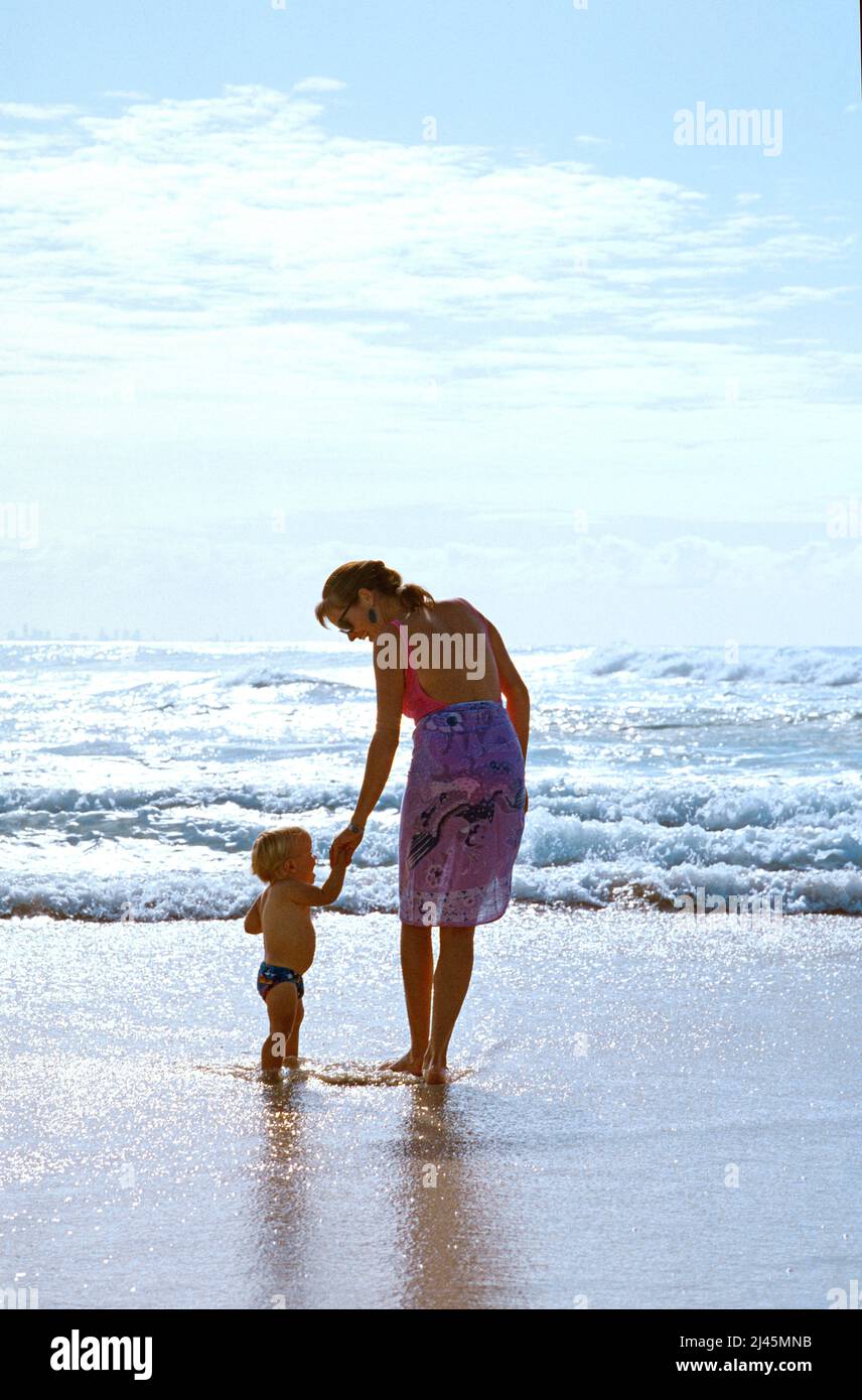 Madre y niño en traje de baño en la playa. Foto de stock