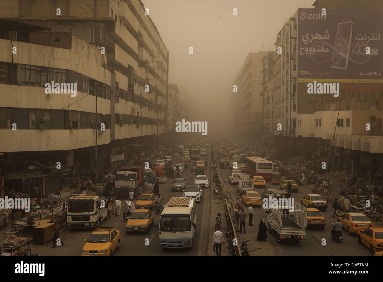 Bagdad, Iraq. 12th de Abr de 2022. Los vehículos conducen en medio de una tormenta de arena en Bagdad. Una tormenta de polvo está envolviendo partes de Irak durante varios días, reduciendo la visibilidad y enviando docenas al hospital con problemas respiratorios. Crédito: Ameer Al-Mohammedawi/dpa/Alamy Live News Foto de stock