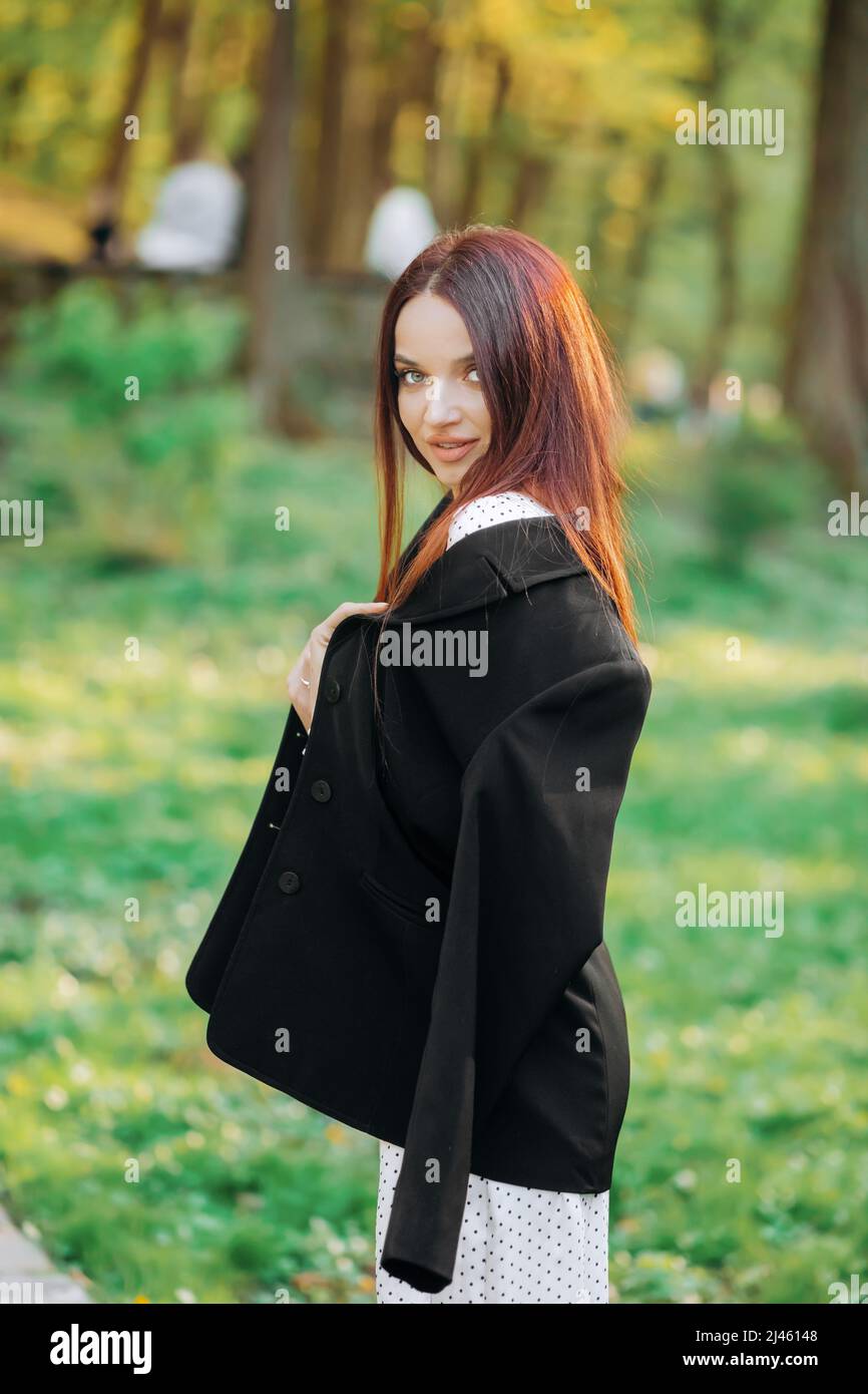 Elegante chica de rojo en una chaqueta posando en Fotografía de stock - Alamy