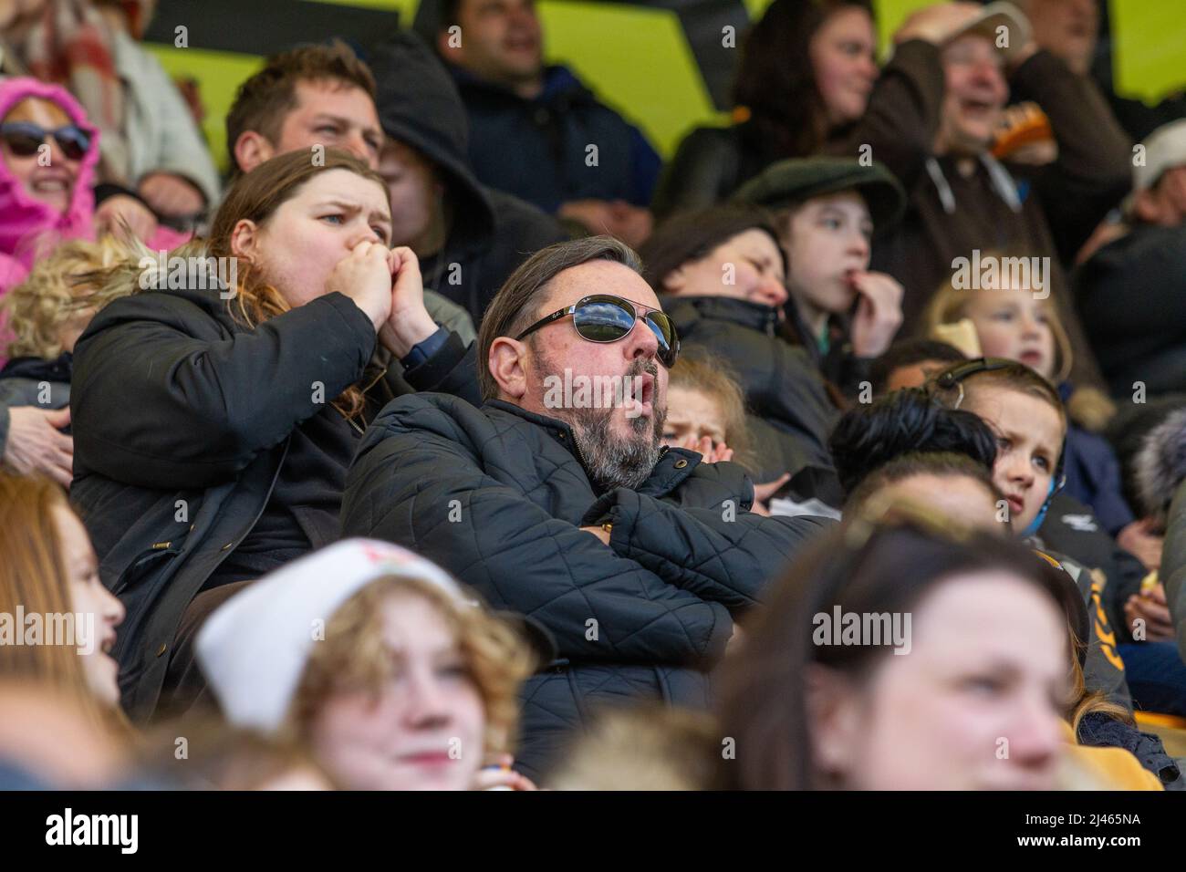 Los aficionados al fútbol y los espectadores con expresiones faciales reaccionan al juego que están viendo Foto de stock