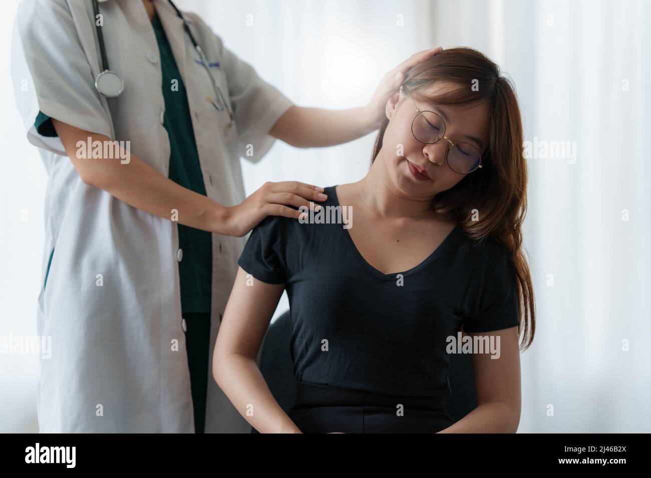 Médico o fisioterapeuta que trabaja examinando el tratamiento de la realización de masajes en el cuello. Concepto de terapia de rehabilitación. Foto de stock