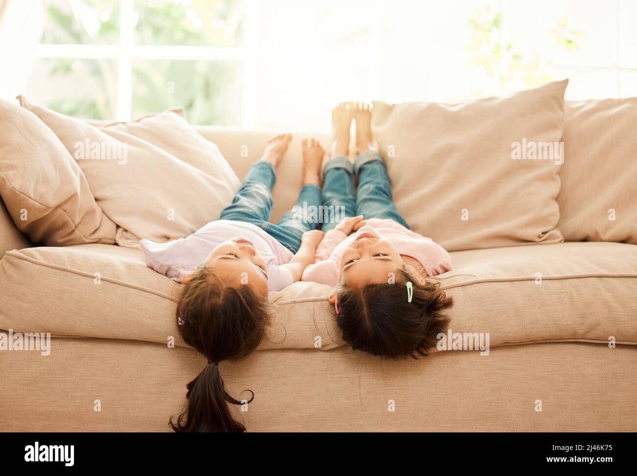 Esquema dulce. Foto de dos hermanas que se pegan en el sofá en casa  Fotografía de stock - Alamy