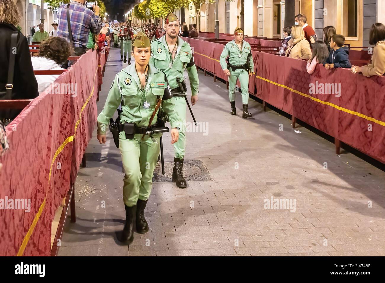 Huelva, España - 9 de abril de 2022: Mujer Soldier desfilar durante la Semana Santa de España por la noche. Legionarios de Legion Tercio durante el desfile Foto de stock