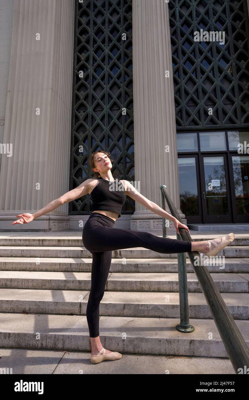 Bailarina adolescente estirando en la escalera del edificio de la psicología de Berkeley Foto de stock