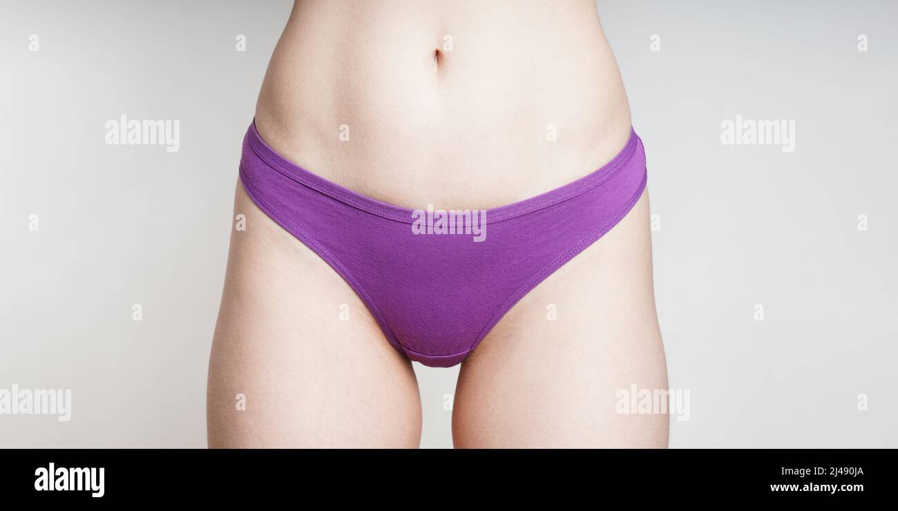 la sección media de la mujer que usa bragas de algodón púrpura como concepto de salud de la mujer Foto de stock