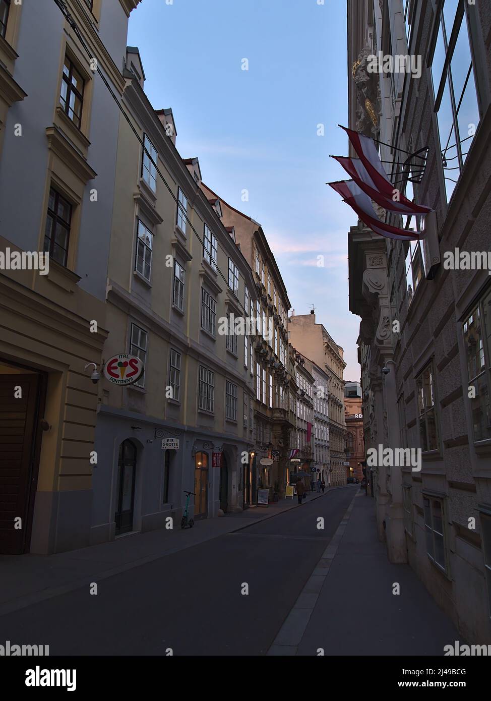 Disminución de la perspectiva de un callejón estrecho Himmelpfortgasse en el centro histórico de Viena, Austria por la noche con tiendas en edificios históricos. Foto de stock