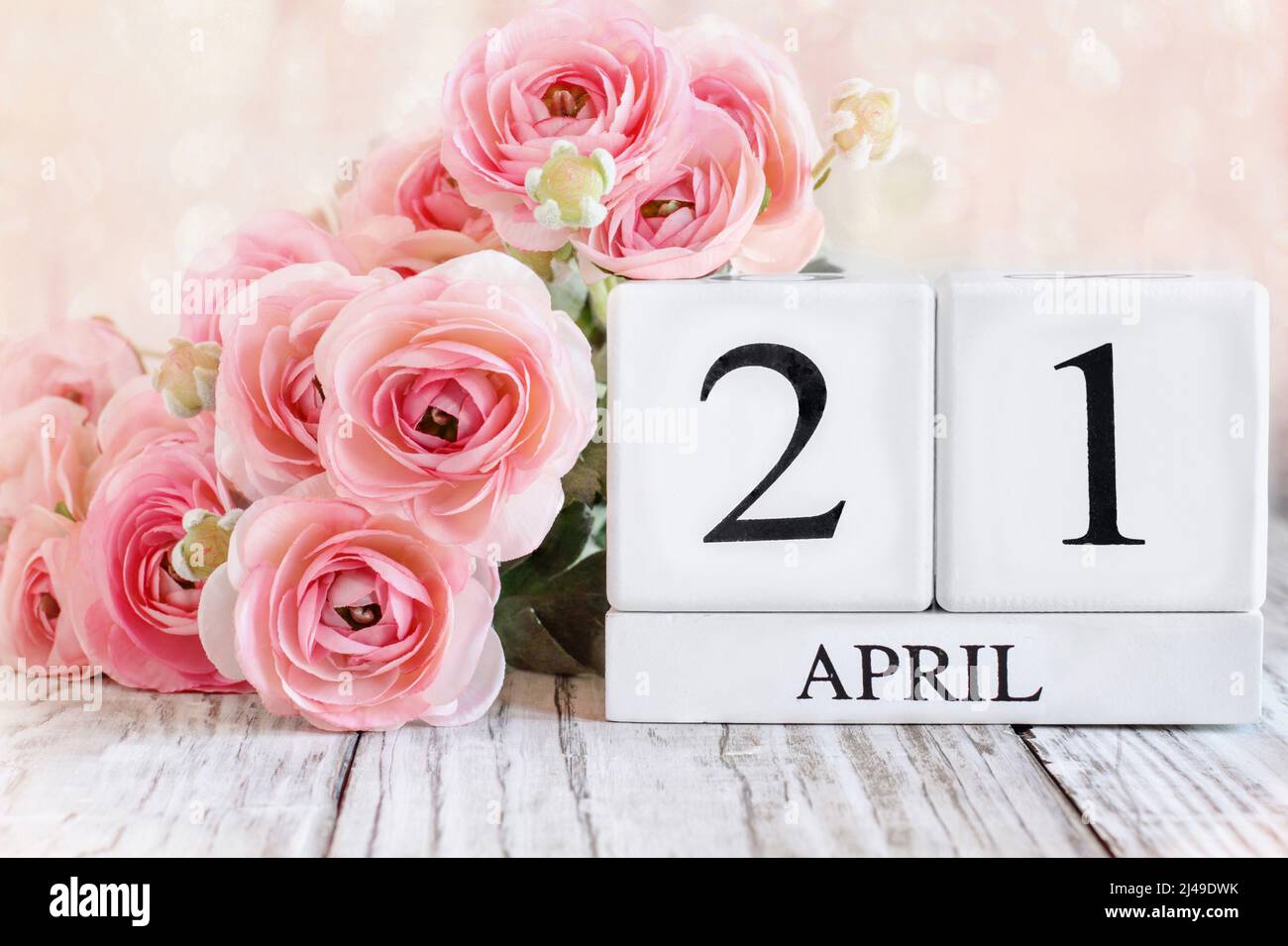 Bloques de calendario de madera blanca con fecha del 21st de abril. Enfoque selectivo con fondo borroso. Foto de stock