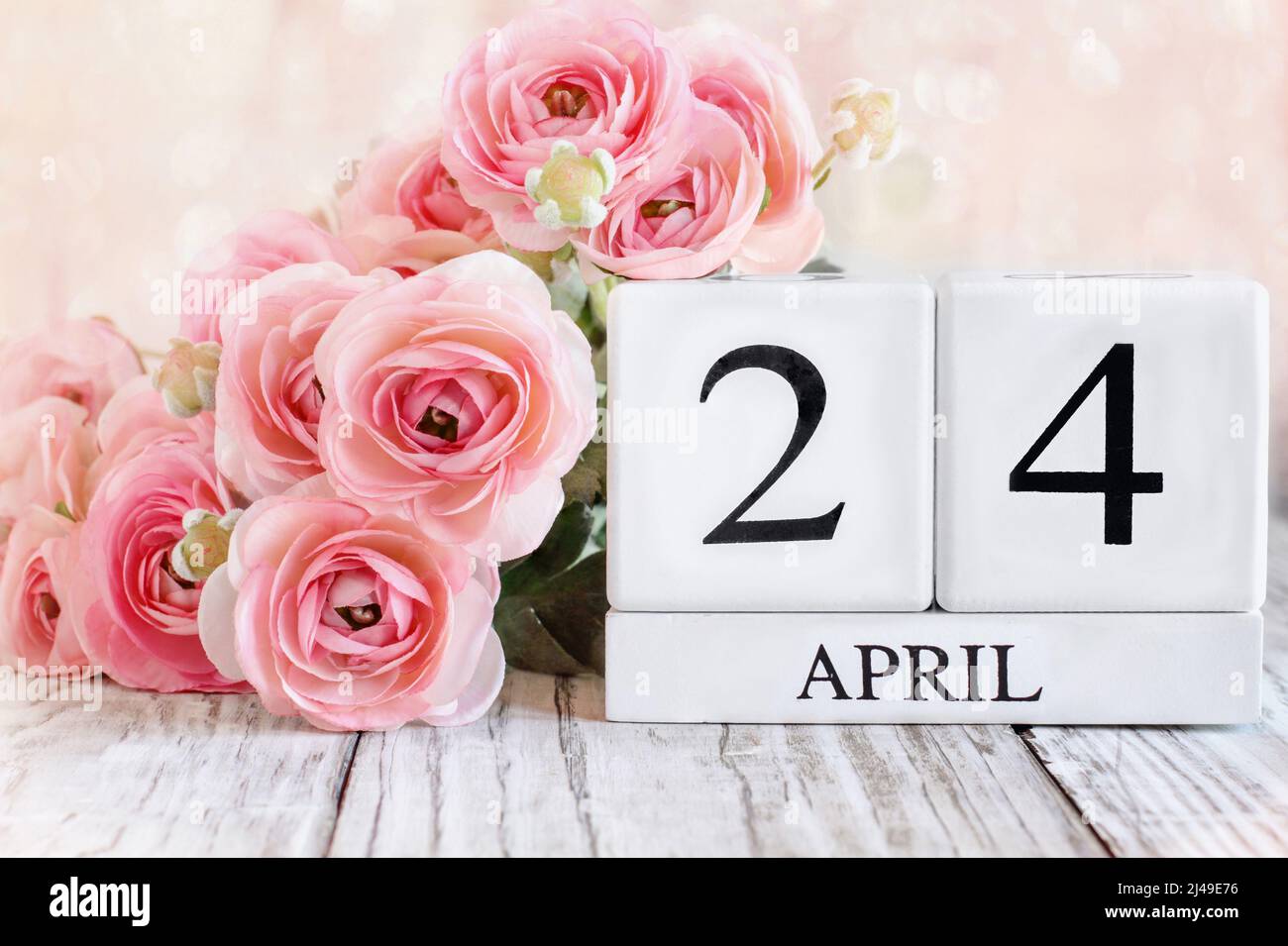 Bloques de calendario de madera blanca con fecha del 24th de abril. Enfoque selectivo con fondo borroso. Foto de stock