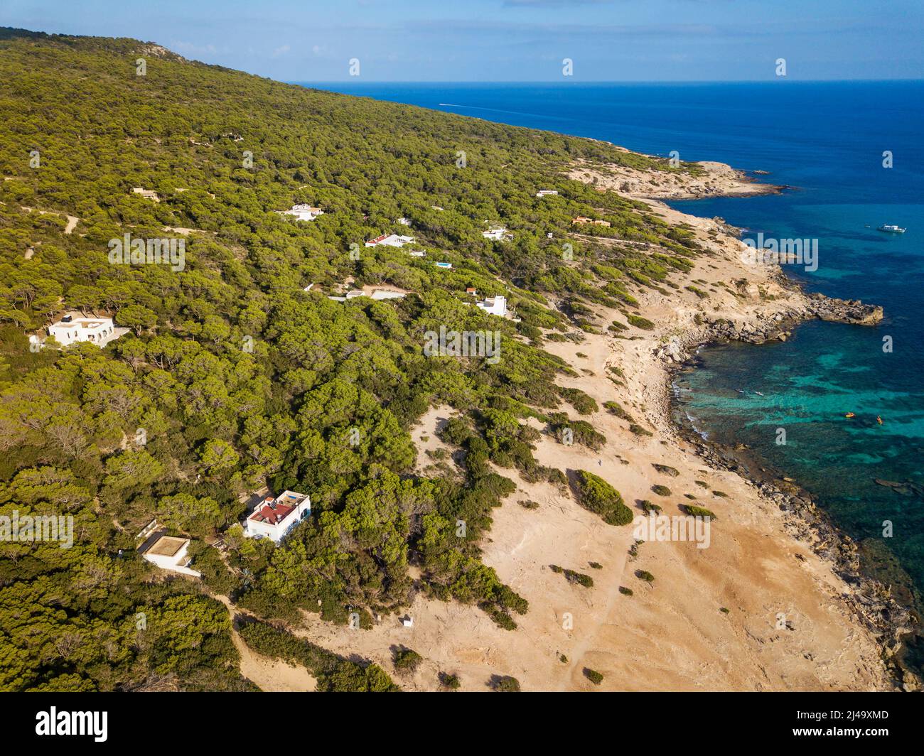 Naturaleza y casas de lujo en la playa de Arenal, cerca de la playa de Es Caló d'es mort cala, con naturaleza verde y salvaje y rocas en la orilla de aguas turquesas, Foto de stock