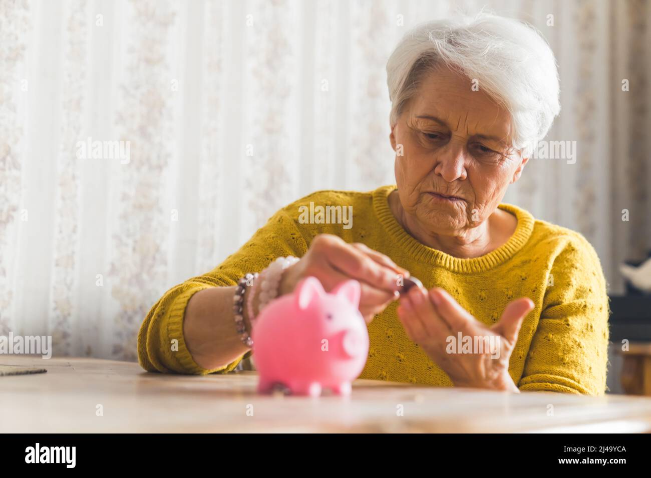 Las Personas Mayores Que Pone El Dinero En Una Hucha Y Mirando A La Cámara  Aislada En El Fondo Blanco Fotos, retratos, imágenes y fotografía de  archivo libres de derecho. Image 66094570