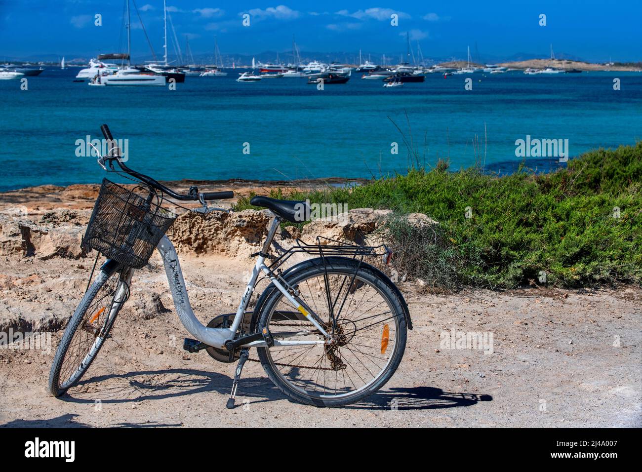Playa Platja Es Cavall d'en Borras con bicicletas en frente de las aguas cristalinas de una costa rocosa, Formentera, Islas Baleares, España. Foto de stock