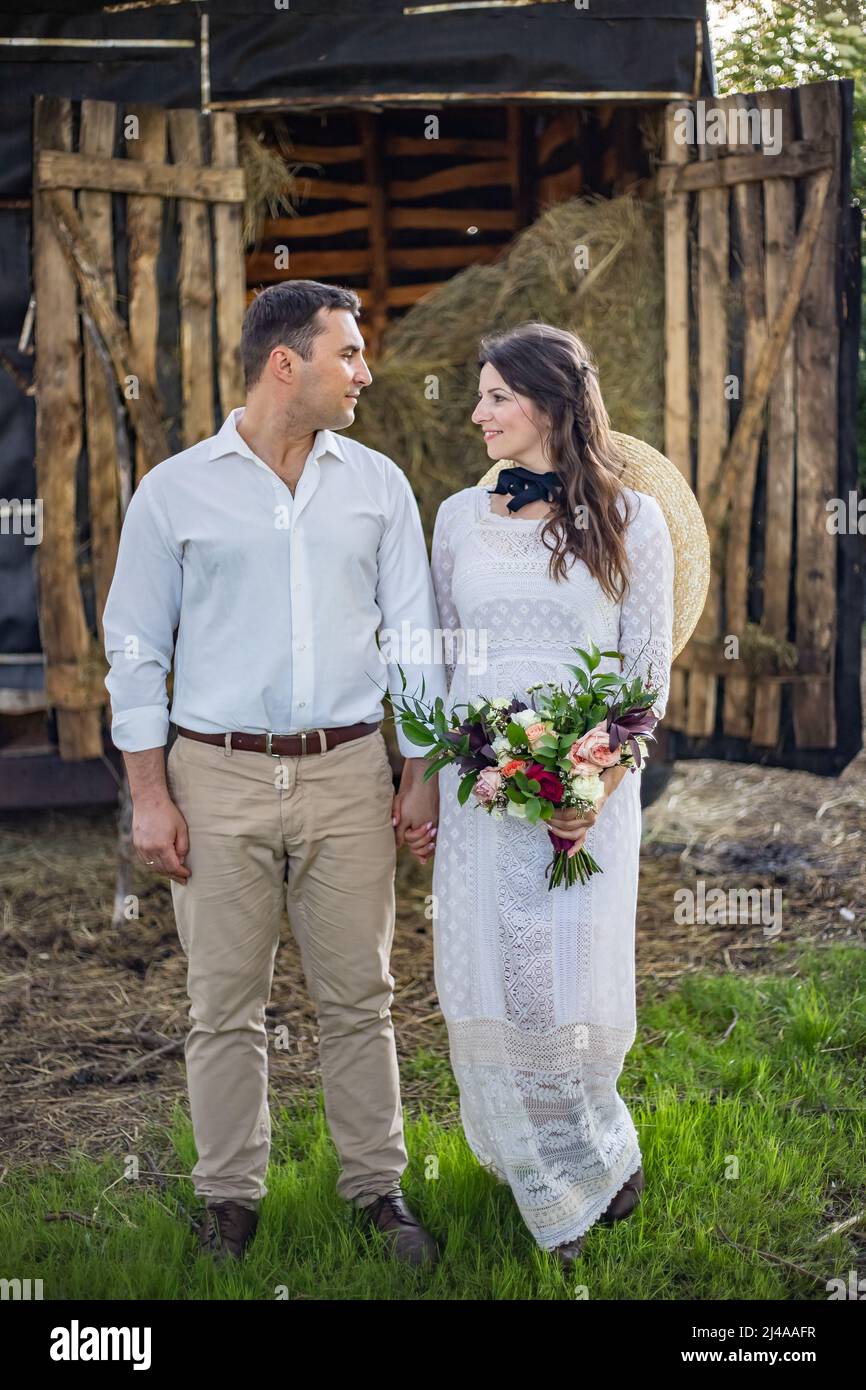 Hermosa pareja de bodas. El novio abraza a la novia firmemente y