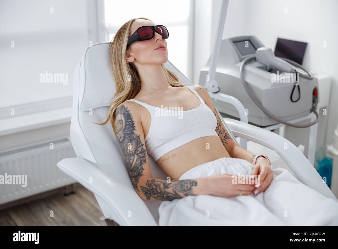 Las hembras jóvenes esteticista llevar gafas protectoras realizar depilación  láser en los hombros de un hombre acostado sobre una mesa en una clínica de  estética Fotografía de stock - Alamy