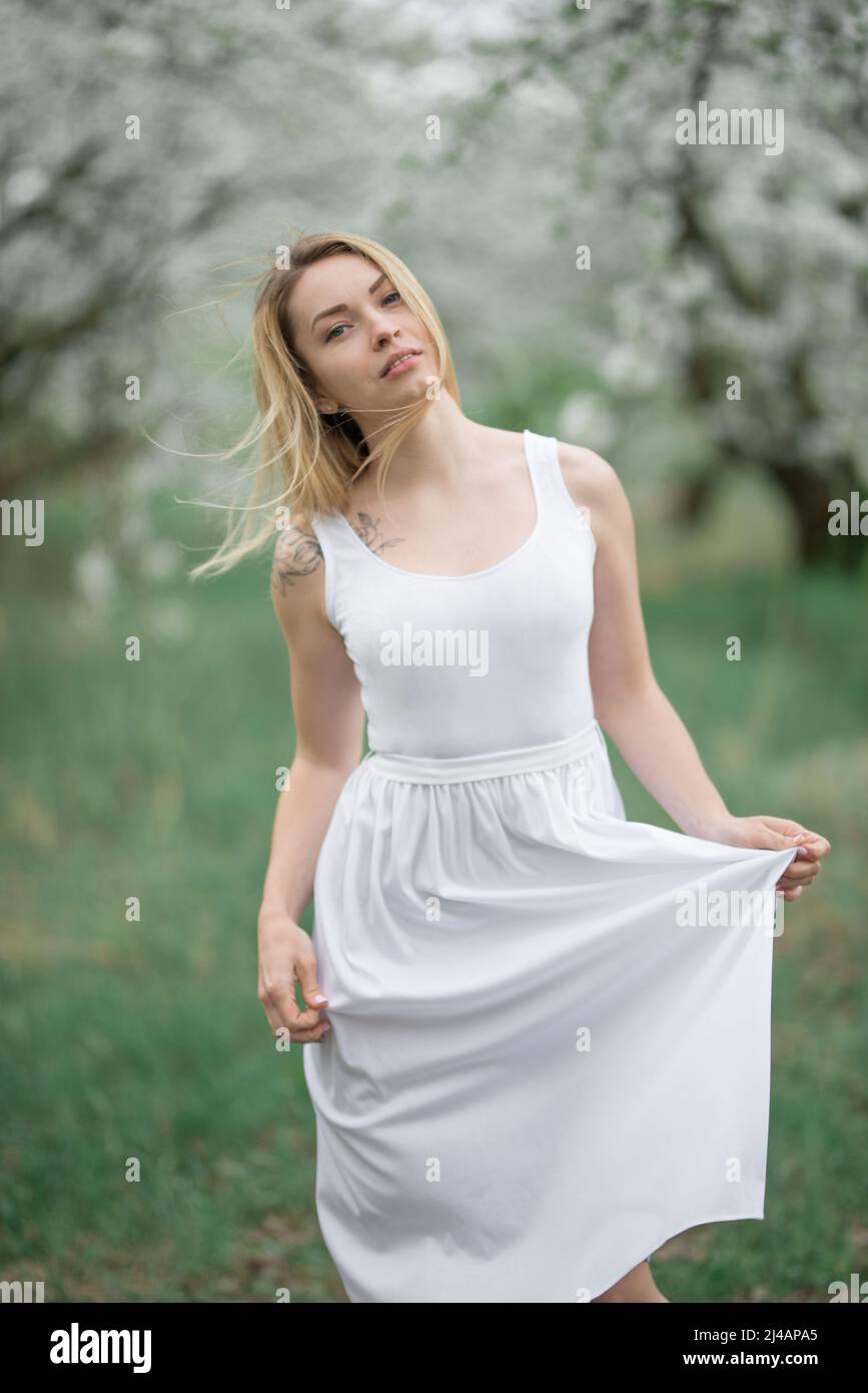 Rubia niña de vestido blanco en florecer jardines primavera Fotografía de stock - Alamy
